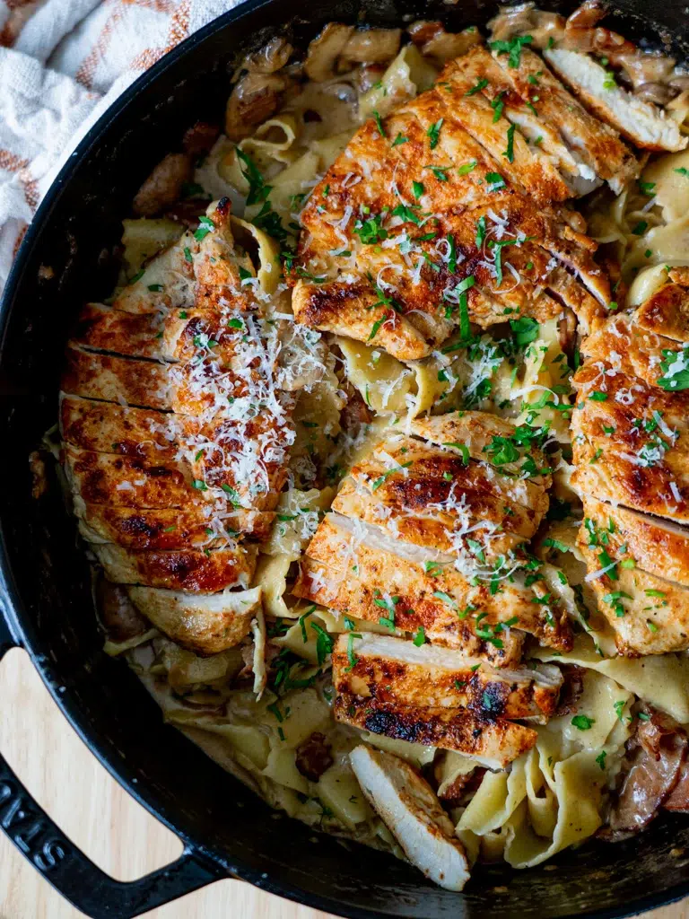 Top view of Chicken Boscaiola Pasta in a pan, featuring a creamy sauce, bacon, and mushrooms.