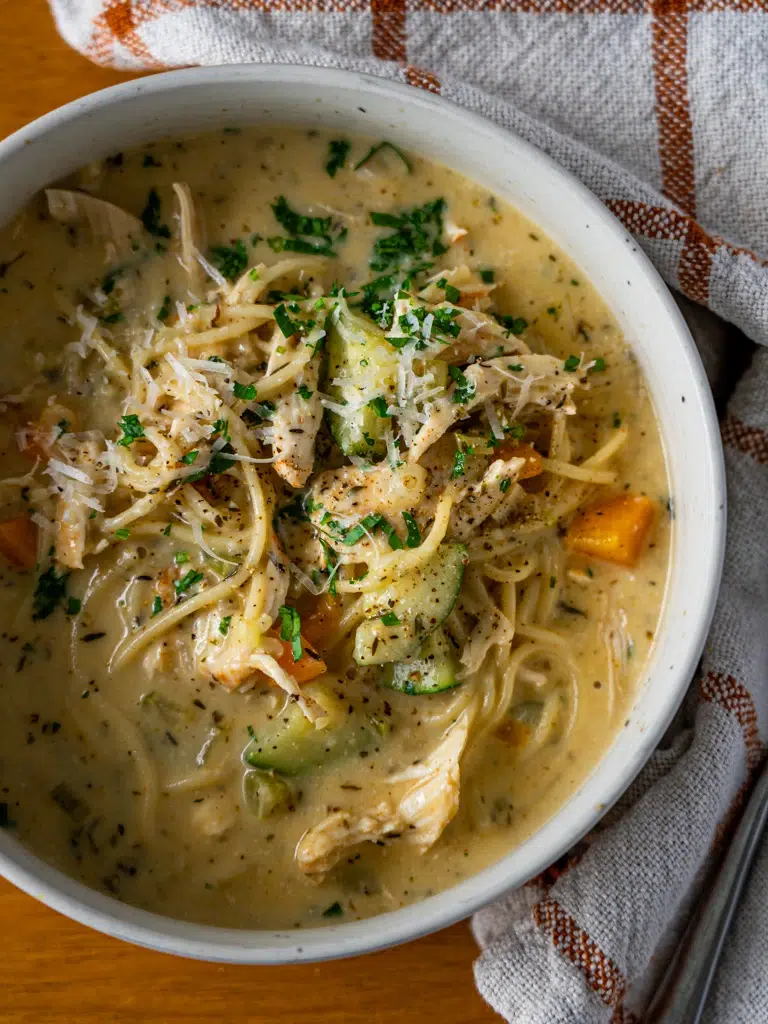 Close-up overhead view of a bowl of creamy lemon chicken noodle soup