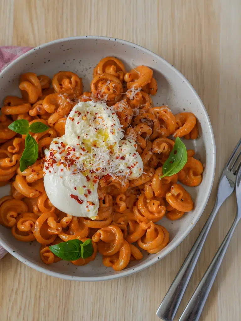 Not Spicy, Not Vodka Pasta served on a plate with a side fork, displaying pasta in a creamy sauce.